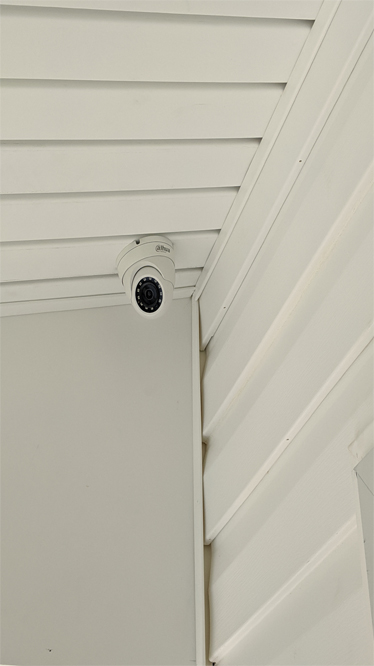 Professionally mounted security camera under a roof